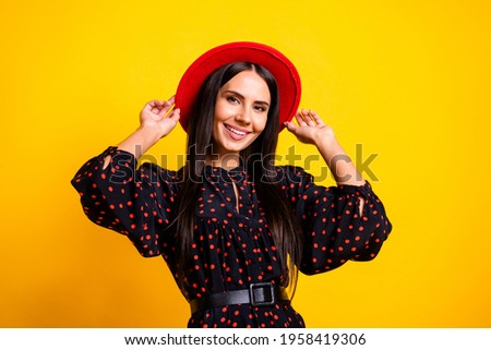 Photo of sweet charming young woman wear dotted outfit arms headwear smiling isolated yellow color background