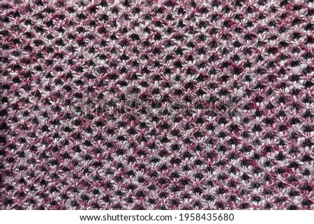 View of thick pink, grey and white woolen fabric with diamonds pattern from above