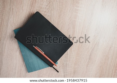 Daily planner on and red pen a wooden table background texture . 