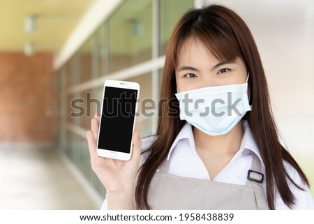 Happy smiling restaurant business worker showing smartphone screen, concept of mobile app, cashless contactless payment application, code scanning, mobile banking technology