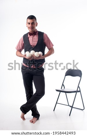 Male juggler on a white background with juggling balls. Place for the test. Juggler's day 