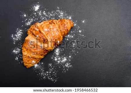 croissant on a black stone background. view from above.