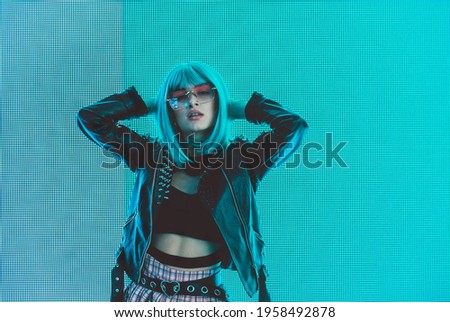Image of a beautiful young woman posing against a led panel. teenager with alternative look and grey wig making urban portraits