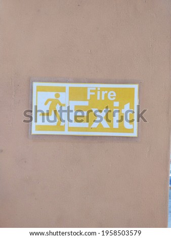 A fire exit image with a running man on the pink background