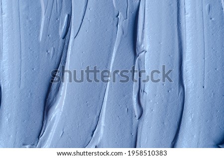 Light blue bentonite facial clay (alginate mask, face cream, body wrap) texture close up, selective focus. Abstract background with brush strokes. 
