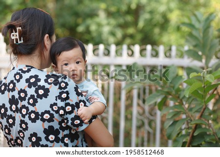 attractive woman carrying little baby boy.