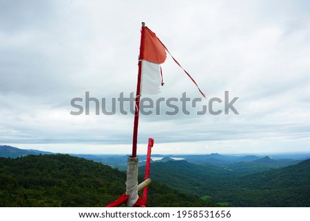 The Indonesian flag, which was starting to become dull, was flying over the mountain, merah putih