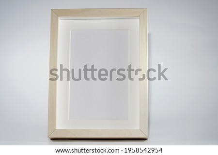 Picture frame with wooden frame photographed frontally in the studio with shadows                          