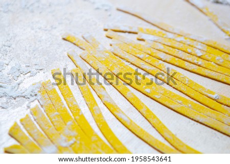 Italian pasta noodles prepared with wholegrain wheat flour on wooden table in restaurant kitchen.tagliatelle preparation.Download royalty free curated images collection with foods on shutterstock