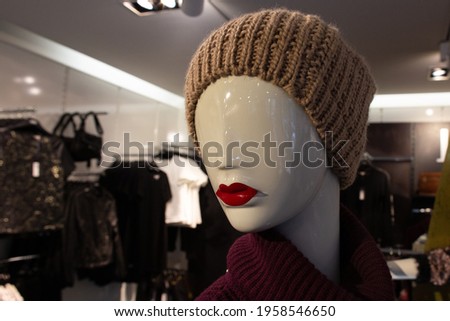 white mannequin head with red lips in knitted cap in clothing store. French Fashion Concept copy space