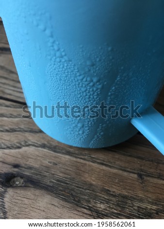 Steam on a blue glass on a wooden table