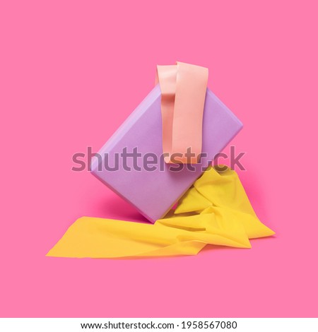 Home workout sports equipment, purple yoga block and yellow elastic bands on bright pink background. Minimal fitness lifestyle.