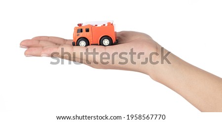 hand holding toys fire truck isolated on a white background.