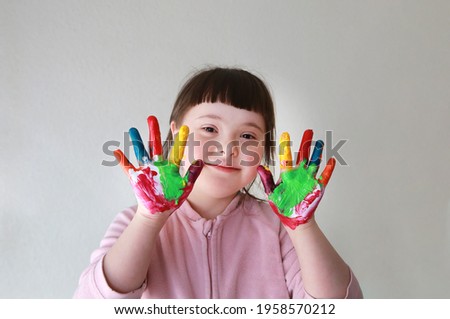 Cute little girl with painted hands.  Royalty-Free Stock Photo #1958570212
