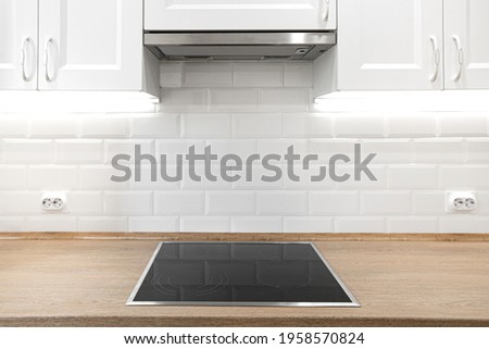 White kitchen with wooden countertop with induction cooktop. Nobody Royalty-Free Stock Photo #1958570824