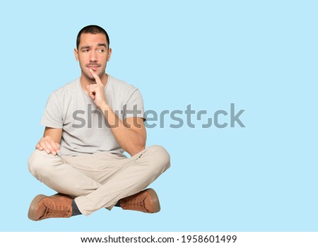 Concentrated young man making a gesture of distrust