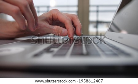 A man is typing something on a laptop