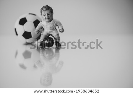 Football game concept, 70s footballer model with a ball with classic pentagons behind it, glossy background and ample space for text.