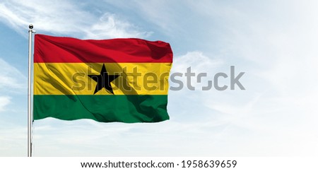 Ghana flag in the blue sky. Horizontal panoramic banner.