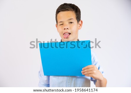 Funny boy holding blue blank paper isolated over white background