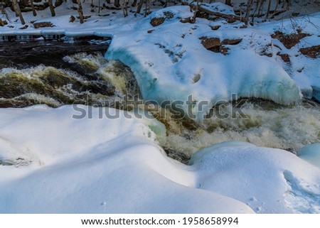 Landscape View of Oxtongue Rapids and Oxtongue River in winter Dwight Ontario Canada, sunny day, ice and snow, Canadian woods