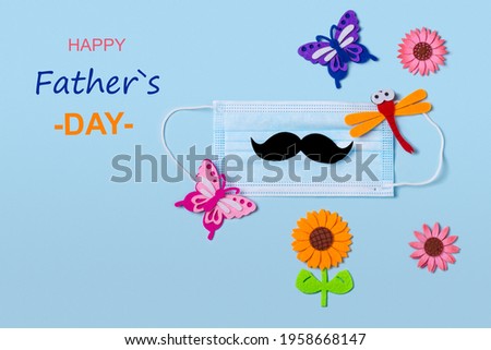 Protective face mask with mens mustache and summer elements on a blue background. The concept of celebrating a birthday or father's day during the coronavirus pandemic. Flat lay.