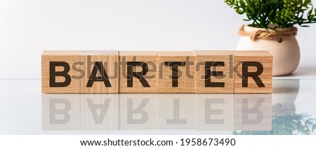 barter word written on wood block. barter motivation text on wooden blocks business concept, white background. Front view concepts, flower in the background
