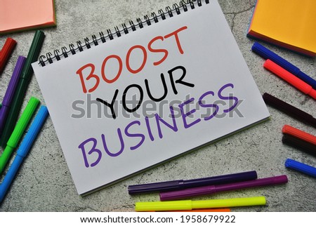 Selective focus of color pen and notebook written with BOOST YOUR BUSINESS. Business, marketing, online selling, sold out concept.