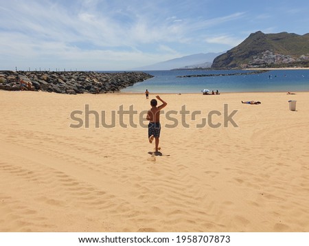 children running on the beach towards ocean 
