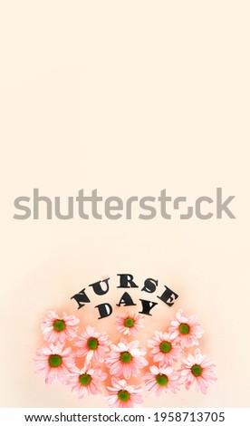 Pink chrysanthemums on a pastel pink background And stylish letters. Top view with copy space. Floral postcard concept. National Doctor's Day. Happy nurse day. Vertical banner.