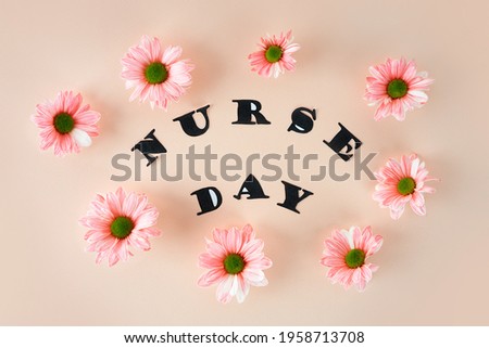 Pink chrysanthemums on a pastel pink background And stylish letters. Top view. Floral postcard concept. National Doctor's Day. Happy nurse day