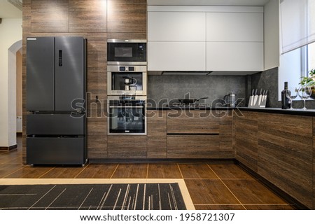 Modern large luxurious dark brown, gray and black cozy kitchen interior Royalty-Free Stock Photo #1958721307