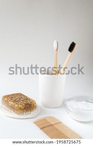 Wooden hair comb, face wash, handmade oatmeal soap, soda, bamboo toothbrushes. Bathroom set. Eco friendly stuff concept. Vertical orientation. Copy space. 