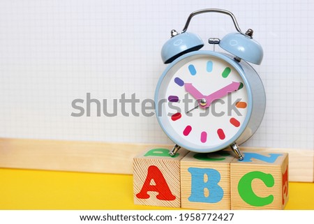 English alphabet. ABC letters on wooden toy blocks. Color funny alarm clock . Copy space.