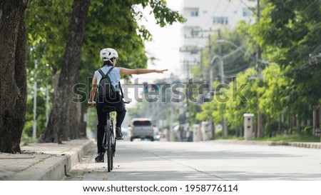 Workers women go cycling in the city to work at rush hour
She gave her arm to the traffic signal. Royalty-Free Stock Photo #1958776114