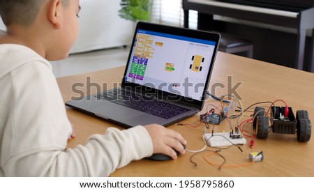 Young asia student remotely learn online at home in coding robot car and electronic board cable in STEM, STEAM, mathematics engineering science technology computer code in robotics for kids concept. Royalty-Free Stock Photo #1958795860