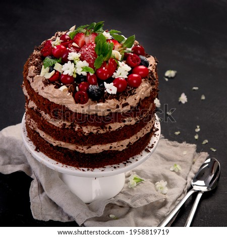 Delicious homemade chocolate cake with fresh berries and mascarpone cream on dark background. Top view, copy space