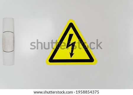 A shield with a yellow triangle and a lightning bolt signifies high voltage. Warning and danger sign