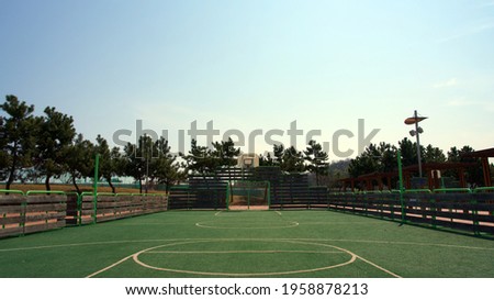 Basketball goalposts and football goalposts in the park.
