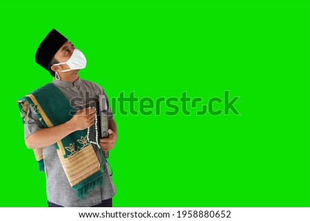 Young muslim wearing a mask view top on green background