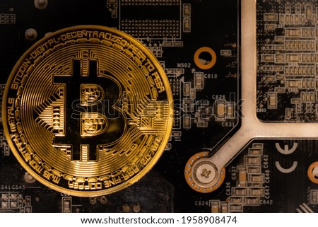 Bitcoins lie on the video card, concept of mining. Electronic virtual money for web banking and international network payment. Symbol of crypto currency. High quality photo