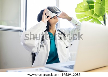 pretty female doctor using virtual reality glasses in consultation