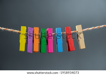 Concept colored wooden clothespins on a ropeclip wooden clothesline colorful. color pink.