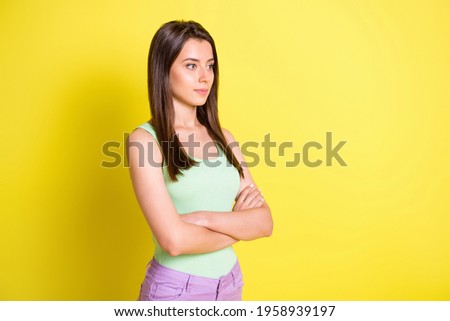 Profile photo of self-assured lady folded hands look empty space wear green top isolated yellow color background