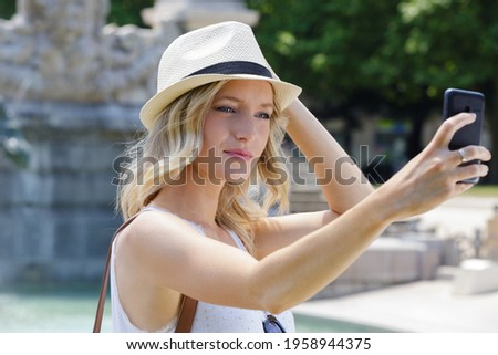 fashionable look young woman doing selfie outdoors