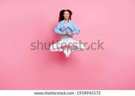 Full length of charming young woman jump air closed eyes make yoga pose isolated on pink color background