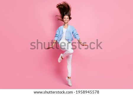 Photo of pretty funny young woman dressed knitted cardigan smiling jumping high isolated pink color background