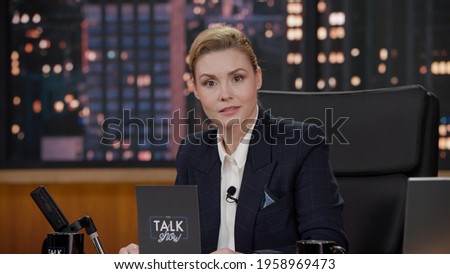 Portrait of late-night talk show female host having a conversation with celebrity guest in a studio. TV broadcast style show