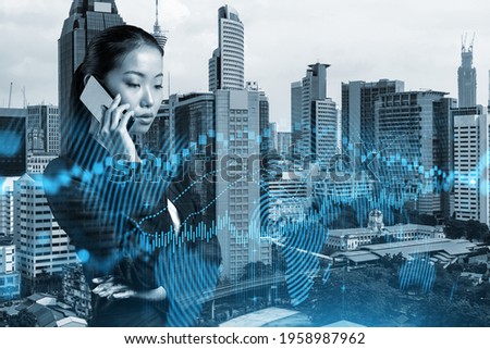 Attractive Asian businesswoman trader processing conference call to forecast the capital market behavior. Concept of trading strategy. Forex chart. Kuala Lumpur. Double exposure.