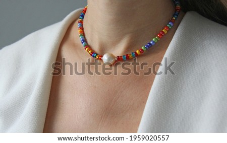 Bright multicolored Venetian glass, pearl of Kasumi necklace. A short necklace on a girl made of natural Kasumi pearl stones. Handmade jewelry made from natural stones. Modern jewelry. Royalty-Free Stock Photo #1959020557
